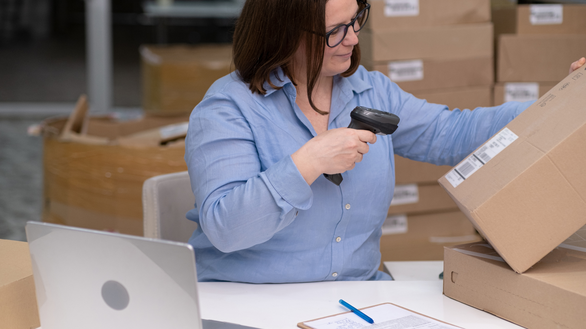 A woman in the warhouse in the process to optimize Purchase Order Management with connected data