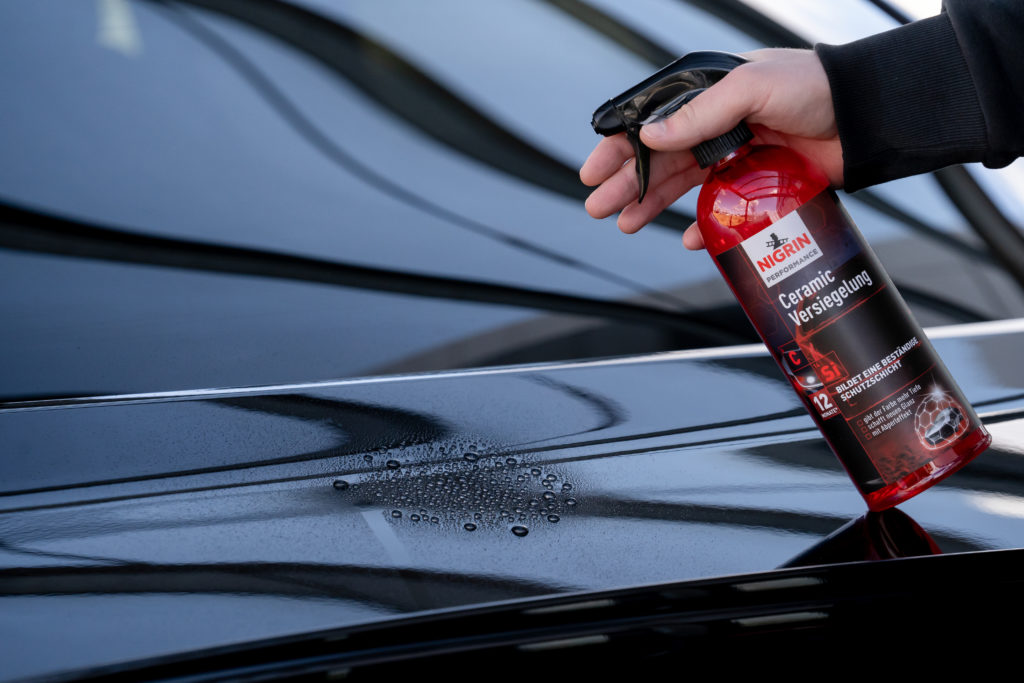 Man spraying Nigrin Ceramic Sealant on a car. Logistics optimized with the help of Setlog OSCA SCM